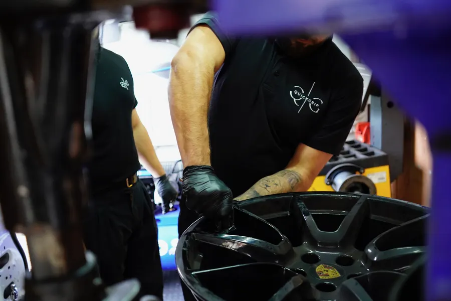 Two QuickGrip technicians working together on a wheel