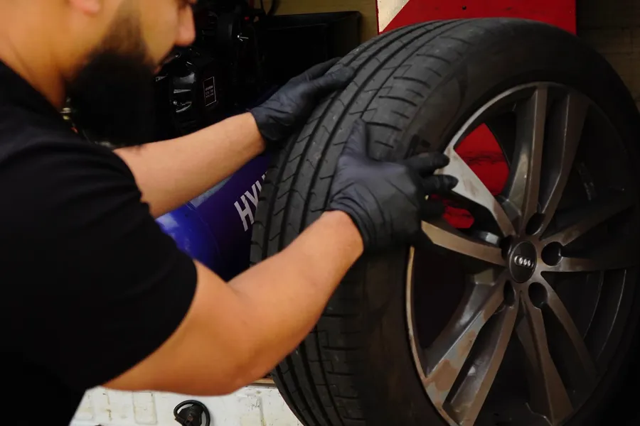 QuickGrip technician handling an Audi tyre and wheel in the van